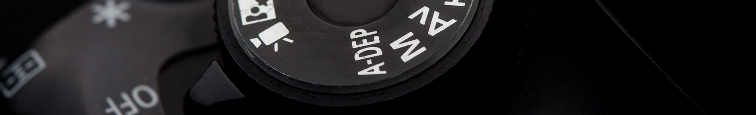 Et programhjul på et kamera med P-program i fokus